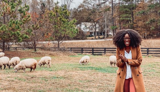 black girl laughing with sheep